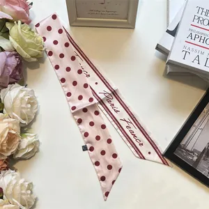 Dettaglio foulard in seta rosa a pois bordeaux con elegante scritta Paris France