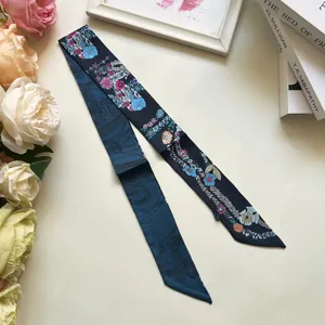 Detalle de un pañuelo de seda floral con patrones botánicos en ambos lados