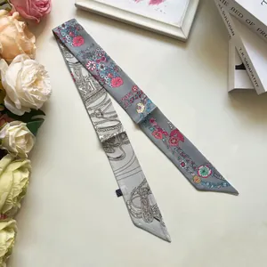 Primer plano detallado del pañuelo de seda de doble cara con motivos florales y ecuestres