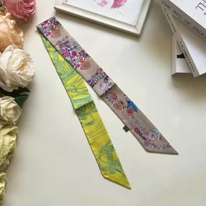 Vista detallada de un pañuelo twilly de doble cara con estampados hípicos y florales