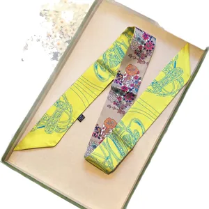 Elegante pañuelo de seda twilly con motivos florales y ecuestres en una caja