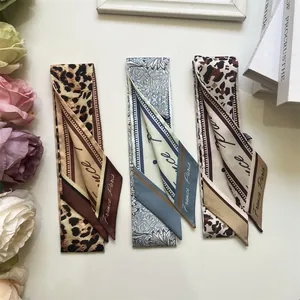Detailed macro of silk-like neck scarves in leopard print and vintage floral patterns