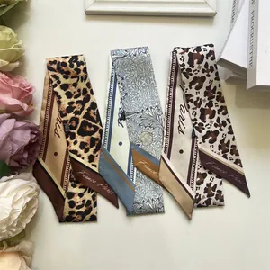 Detail of leopard print and floral silk scarfs laid with rose flowers and props