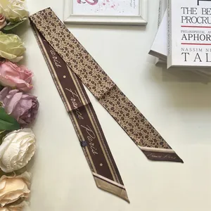 Detail of coffee bean pattern silk scarf and France Paris text on a French retro twilly