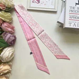 Detail view of pink Twilly silk scarf with polka dots and Paris lettering print