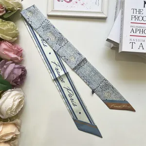 Detail of blue floral Twilly scarf with France Paris script on soft silk fabric