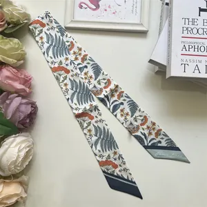 Detailed close-up of a floral silk scarf tied elegantly around a bag handle with France Paris text