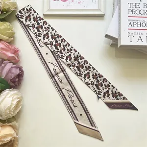 Detail of leopard print silk twilly scarf with elegant France Paris script lettering
