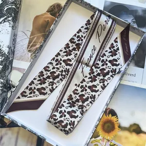 Elegant leopard print silk scarf with France Paris text displayed in a vintage gift box