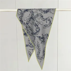 Detalle de pañuelo gris con estampado de serpiente y cadena con borde neón