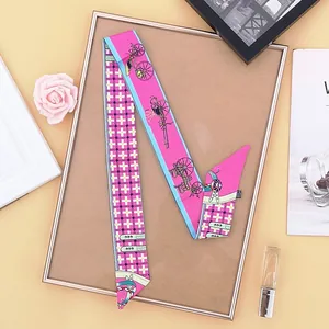 Detail of elegant twilly scarf with carriage pattern and pastel colors for handbags