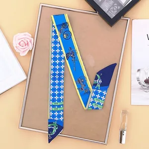 Detail of blue and yellow twilly scarf with horse carriage pattern on luxury display