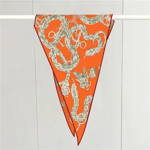 Detalle de pañuelo naranja de lujo con estampados de anclas y cadenas vintage