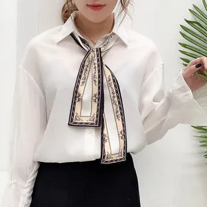 Close-up of elegant white satin shirt paired with a vintage floral print skinny silk scarf