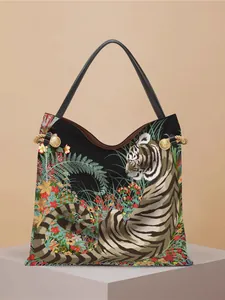 Chic tiger and floral print tote bag with gold metal hardware on light display stand