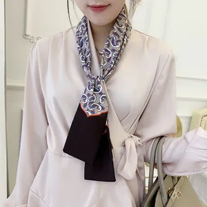 Close-up of double-layer satin scarf featuring classic paisley print and orange wavy trim