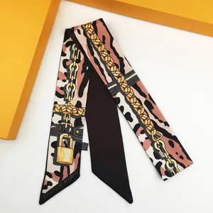 Close-up of leopard print twilly scarf with chain pattern and 100% polyester care label