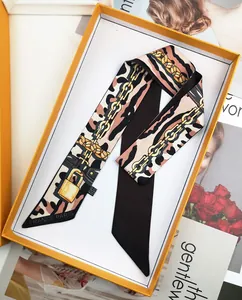 Detail of leopard and gold chain print silk scarf in a premium orange gift box