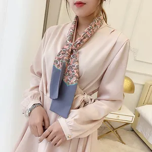 Elegant woman wearing a pink paisley print silk scarf with a satin v-neck wrap dress