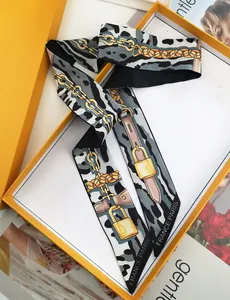 Detail of vintage long silk scarf with leopard print and golden chain pattern in orange box