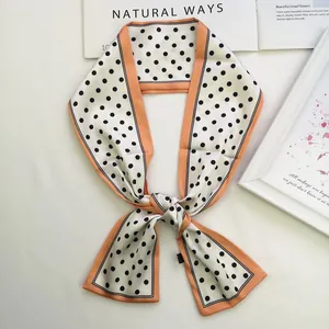 Retro polka dot silk neck scarf with orange trim displayed in an elegant bow tie style