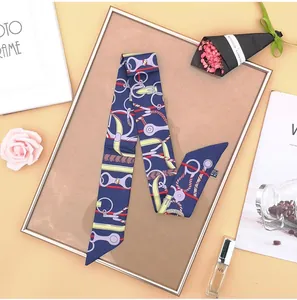 Close-up of navy blue twilly silk scarf with equestrian print and product wash label