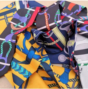Detailed macro view of twill silk scarves with equestrian patterns and metal buckle prints