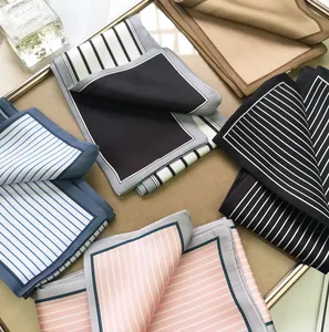 Detail of assorted striped silk scarves neatly arranged in a luxury metal tray