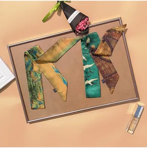Detail of long skinny silk scarves with Chinese landscape and crane art patterns