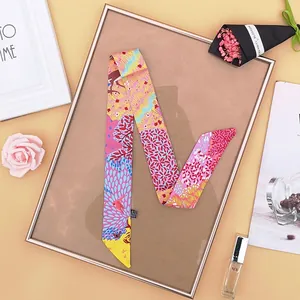 Dettaglio di un foulard twilly multicolore con motivi di foresta, alberi e uccelli