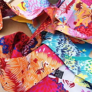 Dettaglio di sciarpe twilly in poliestere con stampe floreali e colori vivaci