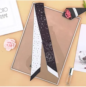 Dettaglio di un foulard twilly in seta bianco e nero con stampe tarocchi stellati e bordi obliqui