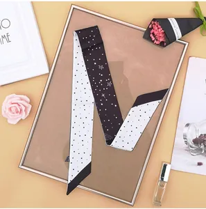 Dettaglio di un foulard twilly double-face con motivi a stelle e pois in stile chic