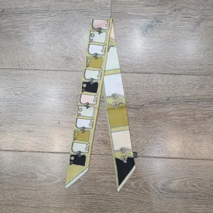 Detail eines bedruckten Seidenschals mit Ketten-Pferdebit-Muster und eingenähtem Etikett