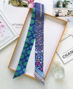 Detailed view of floral Twilly silk scarf with London Paris text and gift box