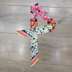 Dettaglio di twilly in raso con stampe floreali di peonie e strisce colorate