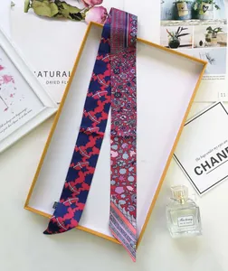 Close-up of a floral silk handle scarf featuring London Paris text in a premium gift box
