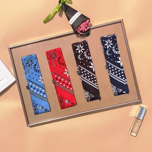 Narrow silk scarves with leopard and paisley star patterns displayed in a wooden tray