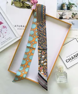 Detail of silk-like twilly scarf with floral patterns and London Paris text in a gift box