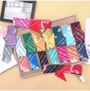Flat lay of diverse paisley and star patterned narrow silk scarves on display board