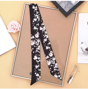 Detailed view of black floral skinny scarf with 100% polyester fabric care label
