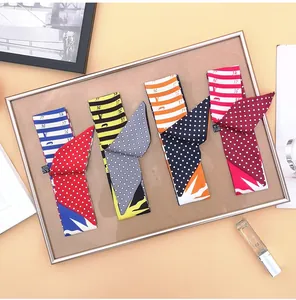 Flat lay detail of four assorted geometric patterns narrow scarves with polka dots and stripes