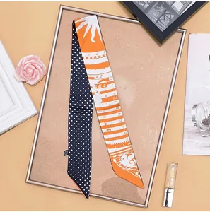 Detailed shot of dual-sided silk twilly with navy polka dots and orange astrology patterns
