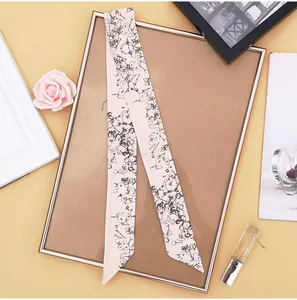 Close-up of pink silk scarf with floral patterns draped on a vintage frame