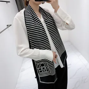 Close-up of black and white striped skinny silk scarf worn with a white blouse