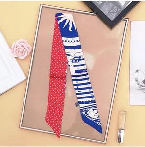Close-up of a double-sided twilly silk scarf with red polka dots and blue sun dial pattern