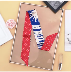 Detail of silk twilly scarf with red polka dots and blue zodiac patterns in gold frame