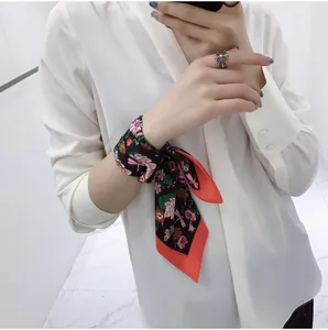 Floral silk scarf tied on wrist as a stylish accessory with butterfly patterns