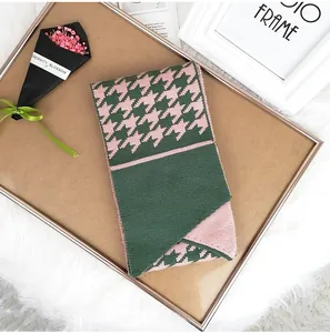 Detail view of pink and green houndstooth knit scarf with soft wool texture