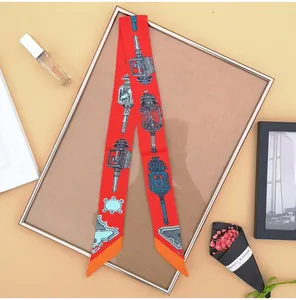 Detail van rode zijden sjaal met vintage lampenprints en oranje contrastranden